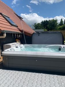 una gran bañera de hidromasaje en un patio en Chambres des marais en Merville-Franceville-Plage