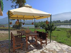 a table and chairs under a large umbrella at The Lakes Lagoon in Plav +27 photos