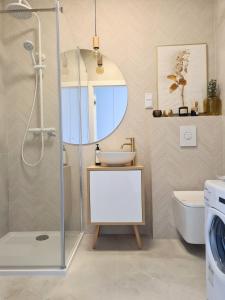 a bathroom with a shower with a sink and a toilet at Royal Sand Apartment in Gdańsk