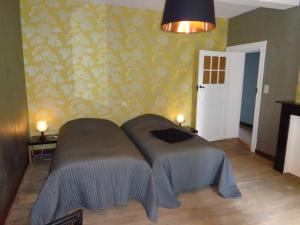 a bedroom with a bed in a room with a wall at Chez Marraine in Nassogne