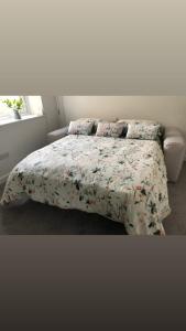 a bedroom with a bed with a floral comforter at Flat 2 Frank Lewis House in Hay-on-Wye