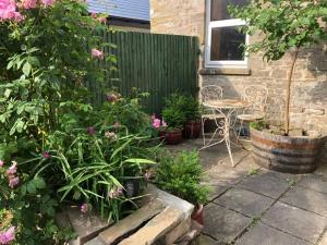 a garden with a table and chairs and flowers at Flat 2 Frank Lewis House in Hay-on-Wye