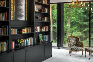 una biblioteca con una silla y estanterías de libros con libros en Grand Chotowa Hotel Spa & Resort, en Chotowa