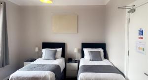 a hotel room with two beds and two nightstands at The Marine in Mallaig