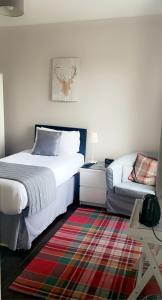 a bedroom with a bed, desk and a lamp at The Marine in Mallaig