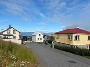 a house with a red roof on a street at Garður restored house in Stykkishólmur