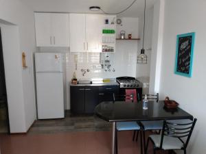 Il comprend une cuisine équipée d'une table et d'un réfrigérateur blanc. dans l'établissement Luminoso Departamento - Sanatorio de la Mujer - Cochera opcional, à Rosario