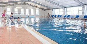 a group of people in a swimming pool at Valley View with a luxurious hot tub in Newquay