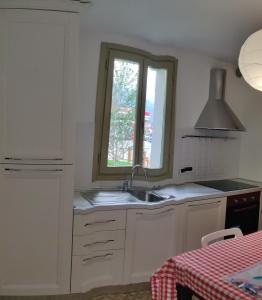 eine Küche mit einem Waschbecken und einem Fenster in der Unterkunft LaCasetta in Saint Vincent