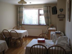 a dining room with tables and chairs and a window at Firtrees Bed & Breakfast in Rostrevor