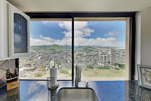a kitchen with a view of a city from a window at Hawaiian Monarch 203 condo in Honolulu