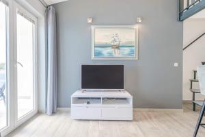 a living room with a flat screen tv on a white cabinet at Ventula in Mimice