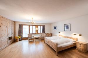 een slaapkamer met een bed en een tafel en stoelen bij Historic Hotel Crusch Alva in Zuoz