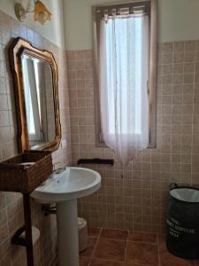 a bathroom with a sink and a mirror at Villa Iole in Assemini