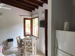 Una cocina con mesa y sillas y un refrigerador. en La Bonita para dos, en Valeria del Mar