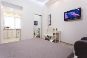 a white room with a bed and a tv on the wall at Modern apartments in the Centre - Kuznechna str. 26/4 in Kharkiv
