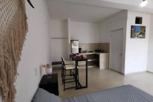 ein Wohnzimmer mit einem Tisch und einer Küche in der Unterkunft Casa en Mahahual cerca de la playa D1 in Mahahual