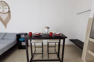 einem schwarzen Tisch mit zwei Stühlen und roten Tassen darauf in der Unterkunft Casa en Mahahual cerca de la playa D1 in Mahahual