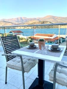 a white table and chairs with a view of the water at King A in Argostoli