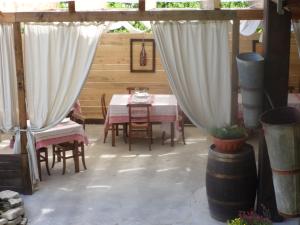 a patio with a table and chairs and curtains at C' Era Una Volta in Canelli