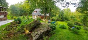 a house in a yard with a large rock in the grass at Za Siódmą Górą in Zachełmie
