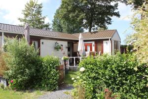 a small house with a garden at Heerlijk chalet op 5* camping in Tuitjenhorn