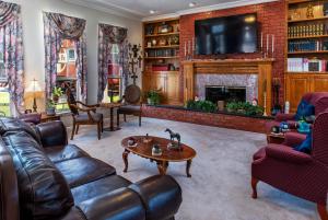 a living room with leather furniture and a fireplace at Woodrow House Bed & Breakfast in Lubbock