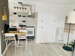 een keuken met een tafel en stoelen in een kamer bij Azzurro house in Cotillo