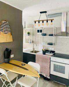 - une cuisine avec une table en bois et des chaises blanches dans l'établissement Azzurro house, à El Cotillo