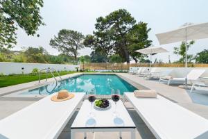 a swimming pool with a table and glasses of wine at Aurum Villas in Ialysos