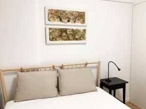 1 dormitorio con 1 cama con 2 cuadros en la pared en Choco House, en Setúbal