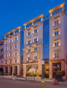 ein großes weißes Gebäude mit vielen Fenstern in der Unterkunft Airotel Stratos Vassilikos Hotel in Athen