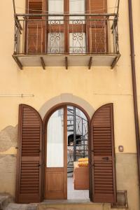 a building with two wooden doors and a balcony at la casa del sarto in Sperlinga