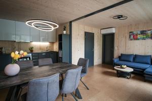 a kitchen and living room with a table and a blue couch at Ferienhaus erholzeit. in Wettringen