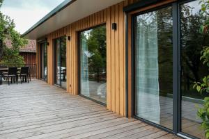 a wooden deck with glass doors and a dining area at Ferienhaus erholzeit. in Wettringen