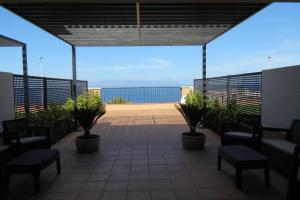 a patio with chairs and a view of the ocean at Luxury House with 3 Bedrooms, Sea Wiew and Swimming Pool in a quiet Residence in Puerto de Santiago