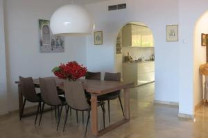 a dining room table with chairs and a kitchen at Luxury House with 3 Bedrooms, Sea Wiew and Swimming Pool in a quiet Residence in Puerto de Santiago