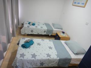 a bedroom with two beds and a table with a bedphasis at Gilad's View in Bet Sheʼan