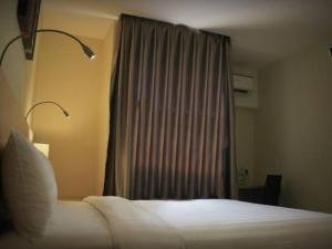 a hotel room with a bed and a window at Biz Hotel Batam in Nagoya