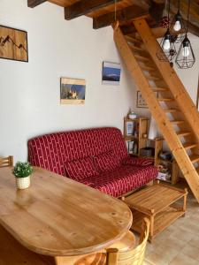 sala de estar con sofá rojo y mesa de madera en La Biolette, en Faverges
