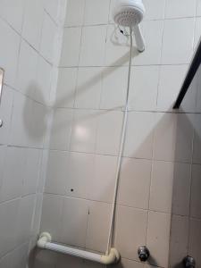 y baño con ducha y pared de azulejos blancos. en Temporada no Paraíso en Ilha Comprida