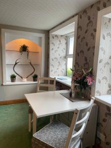 a dining room with a white table and chairs at Forty Five, John Street, Stromness, in Stromness