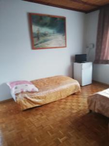 a bedroom with a bed and a painting on the wall at U Halinki in Darłowo
