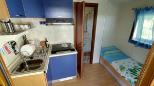een kleine keuken met een wastafel en een klein bed bij la casetta da paola in Bardalone