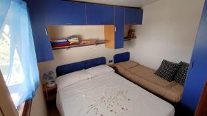een kleine slaapkamer met een bed en blauwe kasten bij la casetta da paola in Bardalone