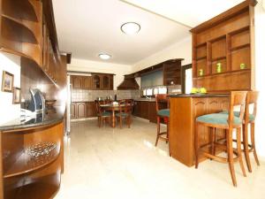 a kitchen with wooden cabinets and a dining room at Patatas Villa in Limassol