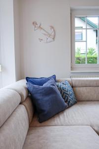 a couch with pillows sitting in a room with a window at Pannonia Lake House in Neusiedl am See