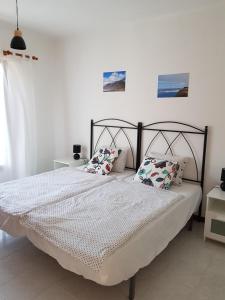 a bedroom with a bed with white sheets and pillows at Casa Olgita in Playa Blanca
