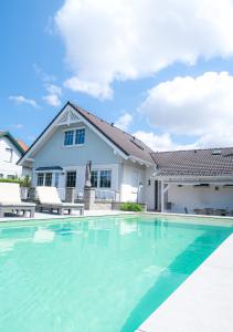 a swimming pool in front of a house at Pannonia Lake House in Neusiedl am See