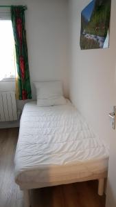 a white bed in a room with a window at appart luz in Luz-Saint-Sauveur